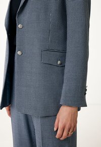 Blå och vit hundtandsmönstrad blazer med silverknappar, skräddarsydd design, en enda framficka och en mjuk tygtextur.