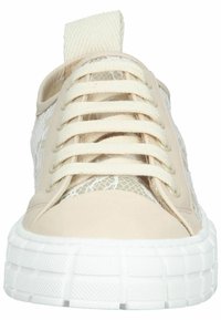 Baskets beiges à lacets avec un panneau latéral en mesh texturé, un bout arrondi et une semelle blanche épaisse. Équipées d'une boucle en tissu à l'arrière.