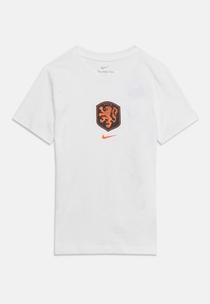 T-shirt blanc à manches courtes de Nike avec un écusson de lion orange et un swoosh Nike orange centrés sur la poitrine.
