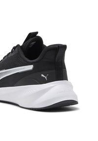 Pantof cu un design sportiv, de culoare neagră, cu partea superioară din plasă, accente albe, o talpă groasă albă și un logo distinct Puma pe spate. Texturat pentru priză.