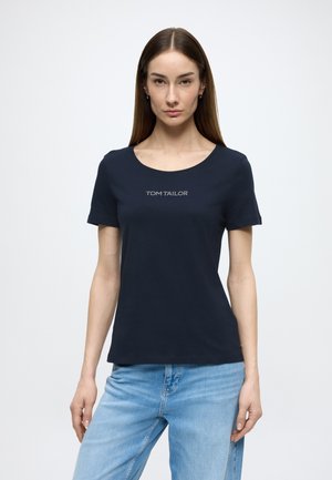 Navy blue cotton t-shirt with short sleeves and a scoop neckline, featuring white "TOM TAILOR" text logo centered on the chest.