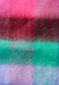 Veltinio audinys su horizontaliomis raudonomis, žaliomis, rožinėmis ir violetinėmis juostelėmis, turintis švelnų paviršių ir spalvų mišinį visame audinyje.