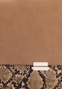 Karmowa skórzana kopertówka z teksturowanym dnem w wężowy wzór, z złotym metalowym zapięciem i subtelnym detalem przeszycia.