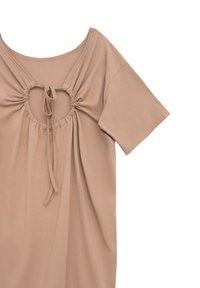 Jasnobeżowa bluzka z krótkim rękawem, wykonana z miękkiego materiału, z marszczonym wycięciem na plecach i regulowanym zapięciem na sznurek.