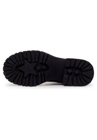 Suela de goma negra con un patrón de banda de rodadura profunda y emblema de estrella, que presenta un diseño grueso y texturizado para una mejor tracción y durabilidad.