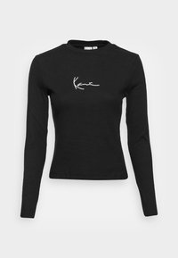 Schwarzes Langarm-T-Shirt aus geripptem Stoff. Verfügt über ein weißes, geschwungenes Logo auf der linken Brustseite und einen klassischen Rundhalsausschnitt.