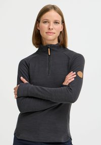 Black zip-up pullover made from soft, textured fabric with raglan sleeves and a leather logo patch on the left arm.