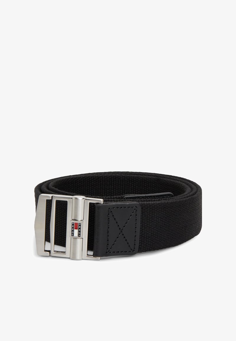 Ceinture en tissu noir enroulée avec une boucle en métal argenté comportant un petit logo rectangulaire Tommy Jeans en rouge, blanc et bleu.