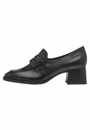 Chaussure en cuir noir à talon bloc avec un bout rond, présentant une sangle décorative sur le cou-de-pied et de subtils détails de couture.