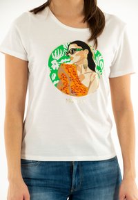 Witte korte mouwen t-shirt met een grafisch ontwerp van een vrouw in een zonnebril, met een oranje top en een groene bladeren achtergrond, versierd met gouden details.