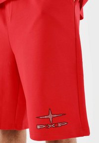 Rode shorts van zachte stof, met een sterrenlogo van rhinestones op het linker onderbeen. Eenvoudig ontwerp met een comfortabele pasvorm.