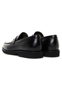 Black leather loafers with textured finish, cushioned insole, and flat rubber sole. Features a classic penny slot design on the vamp.
