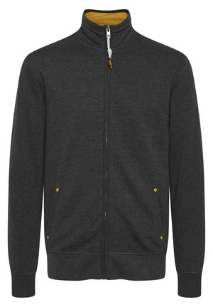 Chaqueta de cremallera gris oscuro con cuello alto, forro interior amarillo y dos bolsillos laterales con acentos amarillos. Tejido suave y texturizado.