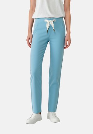 Light blue pants made of stretchy fabric, featuring a white drawstring waist, slim fit, and side accent seams, paired with white sneakers.