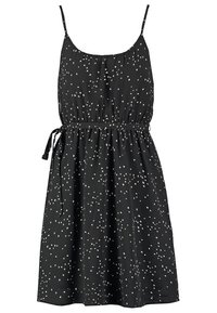 Robe noire sans manches avec fines bretelles, motif à pois blancs dispersés, taille froncée et ceinture à nouer sur le côté.