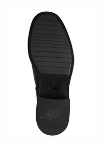 Schwarze Schuhsohle mit strukturierten Oberflächen, ausgestattet mit horizontalen Rillen und einer runden Zehe. Entwickelt für Grip und Stabilität mit Markenlogo.