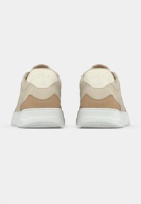 Baskets beiges avec un dessus en cuir lisse et des accents en daim, comprenant une semelle en caoutchouc blanche et un logo sur la languette arrière.