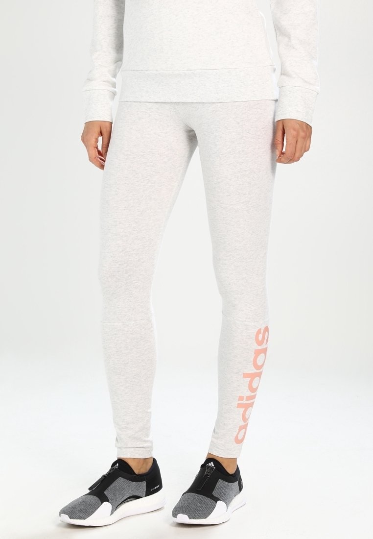 Jasnoszare legginsy z elastycznego materiału, o dopasowanym kroju, z wyraźnym różowym logo "adidas" na lewej nodze.