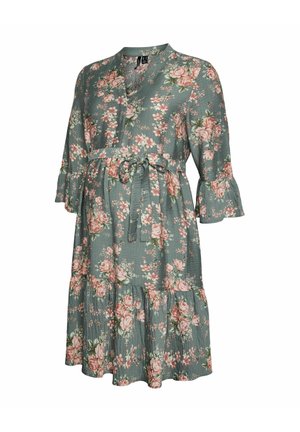 Vestido verde con flores hasta la rodilla, con mangas de 3/4 con volantes y cinturón de lazo en la cintura, con flores rosas y blancas.