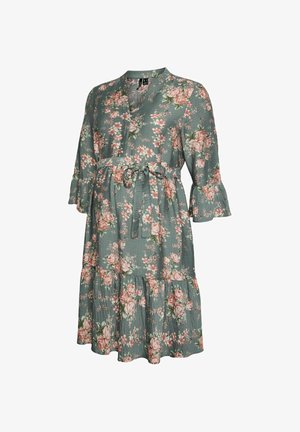 Zelena dolga obleka z rožami do kolen, s 3/4 nabranimi rokavi in pasom, zavezanim v pentljo, okrašena z roza in belimi cvetovi.