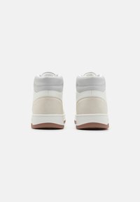 Sneaker alte con tomaia in pelle bianca, dettagli in suede beige, colletto in sintetico grigio e suola in gomma naturale.