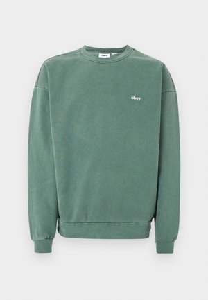 Πράσινο φούτερ με στρογγυλή λαιμόκοψη, μακριά μανίκια και μικρό λευκό λογότυπο "obey" στο αριστερό στήθος.