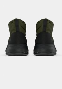 Fekete és olíva zöld sportcipők párnázott gallérral, elegáns dizájnnal és texturált fekete talppal. Hátsó húzófüllel a könnyű felvétel érdekében.