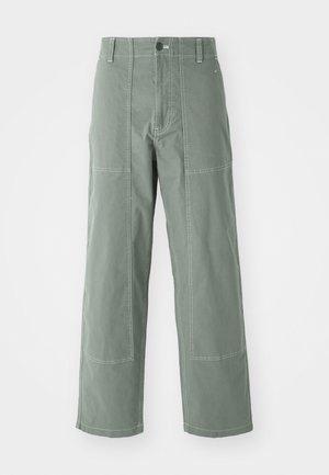 Zöld cargo nadrág laza szabással, jellemzője a folt zsebek, kontrasztos varrás, elülső gombos záródás és egyenes szár kialakítás.