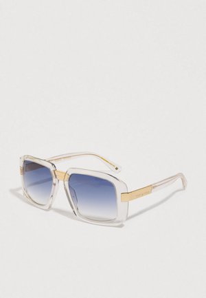Transparente Sonnenbrille mit quadratischem Rahmen, blauen Verlaufs-Gläsern und goldenen Akzenten an den Bügeln und der Brücke.