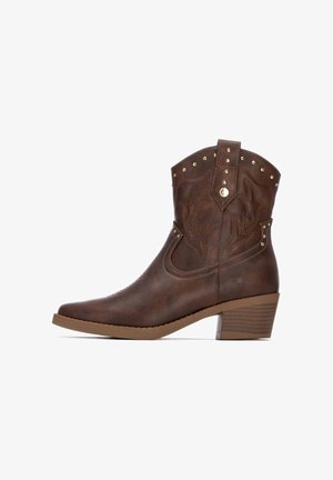 Botas de cowboy de imitación cuero marrón con punta afilada, costuras decorativas, acentos de tachuelas y un tacón bajo en bloque. Con tirador lateral para mayor comodidad.