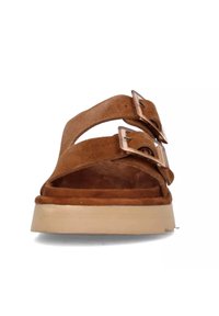 Bruine suède sandalen met twee brede banden met rechthoekige metalen gespen, een beige platformzool en een zachte, gestructureerde binnenkant.