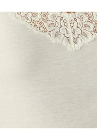 Camiseta de tejido suave con un escote de encaje con borde ondulado, con patrones florales y un sutil texturizado a rayas en toda la prenda.