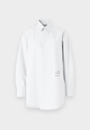White long-sleeve shirt made of lightweight fabric; features a button-down collar, loose fit, and printed logo detail on the side.