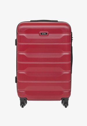 Czerwona walizka twarda z teksturowaną powierzchnią, poziomymi rowkami, dwoma uchwytami bocznymi i czterema kółkami ułatwiającymi przemieszczanie.