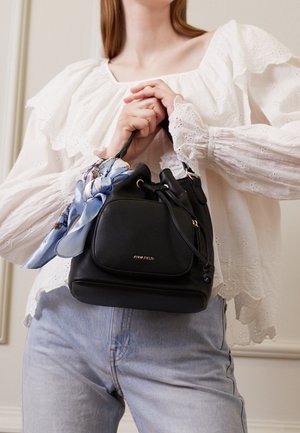 Zwarte leren bucketbag met een getextureerde afwerking, voorzien van gouden hardware en een lichtblauwe sjaal met patroon, vastgeknoopt aan het handvat.