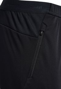 Schwarze Sportshorts mit strukturiertem Bund und einer seitlichen Reißverschlusstasche. Das Material ist leicht und flexibel.