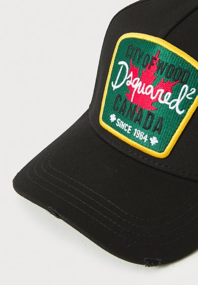 Schwarze Kappe mit strukturiertem Design, ausgestattet mit einem grünen Patch, gelbem Rand und gesticktem roten Ahornblatt, geprägt mit "Dsquared²" und "Kanada."