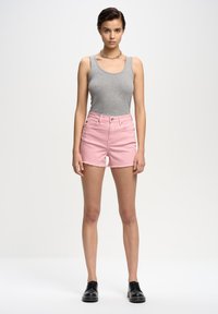 Pelēks bezpiedurkņu topiņš kombinēts ar gaiši rozā dženimšortiem ar saplēstām malām un melniem šņorējamiem apaviem. Vienkārša, ikdienišķa izskata kombinācija.