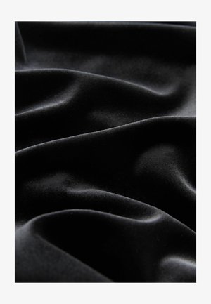 Juodas aksominis audinys su lygia tekstūra, rodantis švelnius raukšles ir klostes, pabrėžiantis jo švelnią, prabangią išvaizdą.