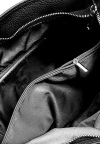 Sac en cuir noir avec une texture lisse et des garnitures en argent. L'intérieur comprend une doublure douce, une poche zippée et un compartiment principal spacieux.