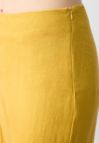 Linnen rok in een levendige gele kleur, met een zachte textuur, slim fit en een discrete zijrits.