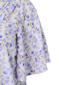 Blouse à manches courtes à fleurs en tissu léger, avec un fond blanc orné de fleurs bleues et violettes ainsi que de fines branches brunes.