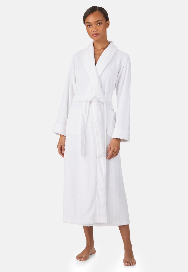 Biały szlafrok wykonany z teksturowanej bawełny, z kołnierzem typu szal, długimi rękawami, paskiem wiązanym oraz przednimi kieszeniami z subtelnym wzorem.