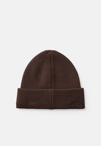 Bruine gebreide beanie met een geribbelde textuur en opgerolde rand. Heeft een ronde bovenkant en verticale naaddetails.