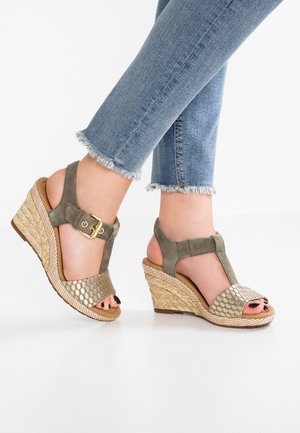 Zielone oliwkowe sandały na koturnie z metaliczną teksturowaną cholewką, detalem z klamrą i plecioną podeszwą z juty. Otwarty przód, jasnobrązowa wkładka.