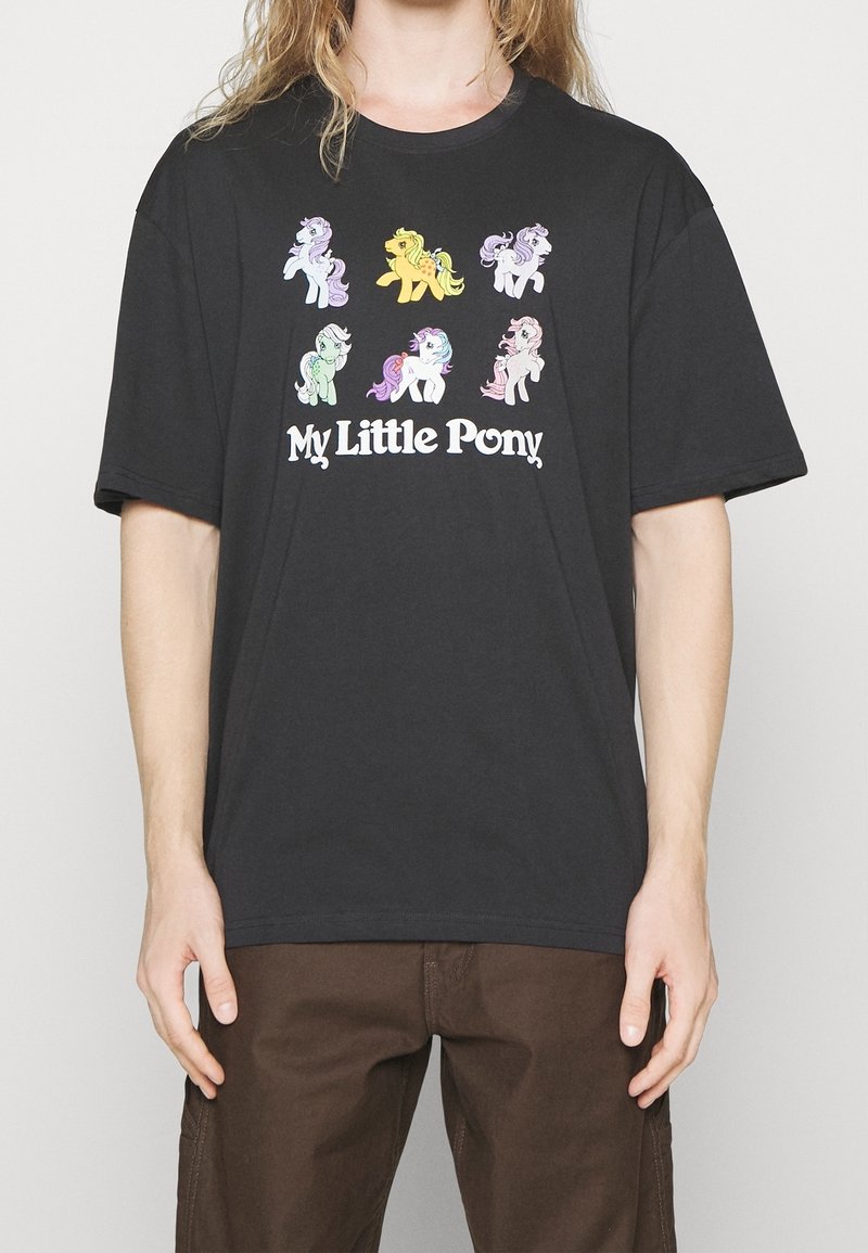T-shirt noir en coton avec des graphismes colorés de My Little Pony. Coupe décontractée avec un col rond et des manches courtes.