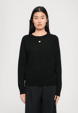 Pull noir à col rond et manches longues, avec un petit détail en forme de cœur blanc sur la poitrine. Fabriqué dans un tissu doux et texturé.