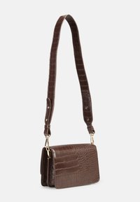 Sac à main en cuir embossé crocodile marron avec une forme rectangulaire, une bandoulière réglable et des accents en métal doré. Texture lisse avec une finition brillante.