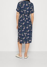 Navy blue floral dress with short sleeves, belted waist, and side slits; features pink flowers and green leaves, made from a smooth fabric.