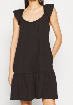Robe en coton noire avec un décolleté en forme de cœur, des manches en capes froncées et une jupe à volants, présentant une texture douce et une coupe décontractée.